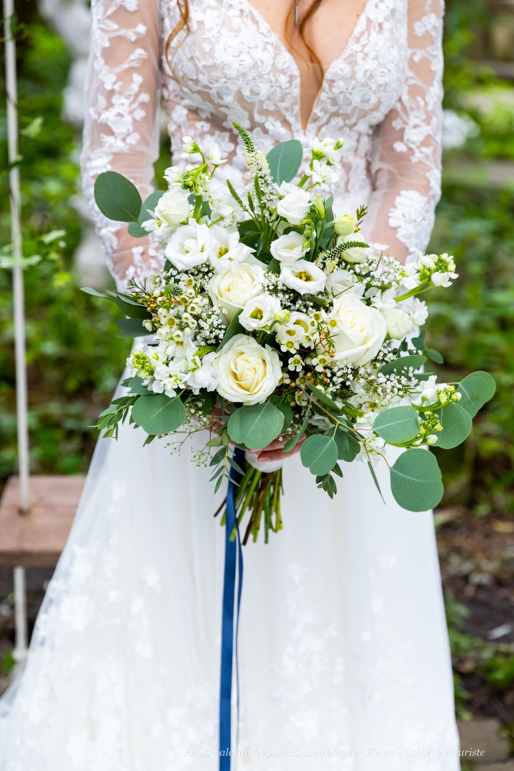Gros plan bouquet de mariée blanc avec roses, lisianthus, véronique, wax
et eucalyptus, mariée floue en arrière-plan
