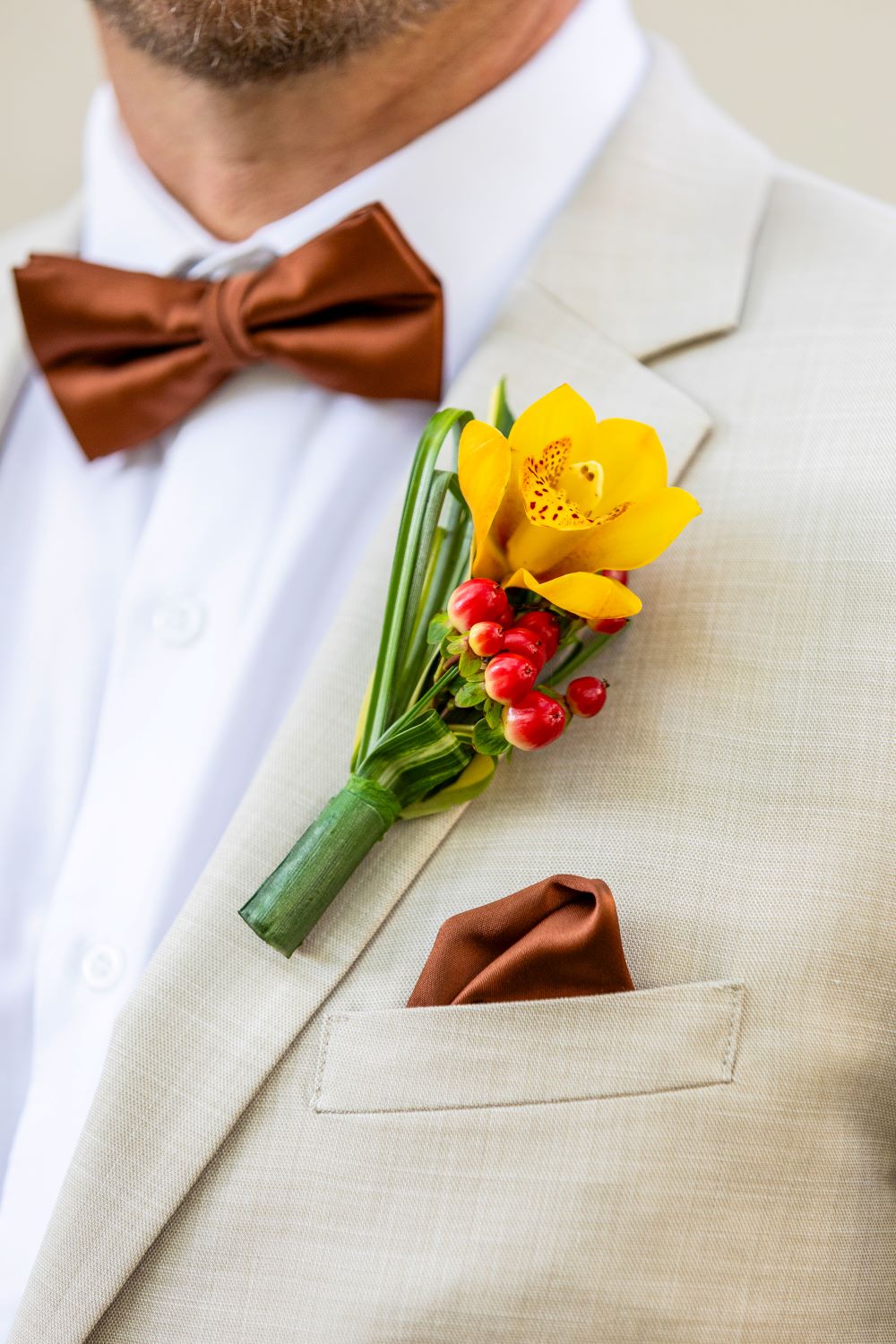 Boutonnière du marié pour mariage exotique rouge et jaune