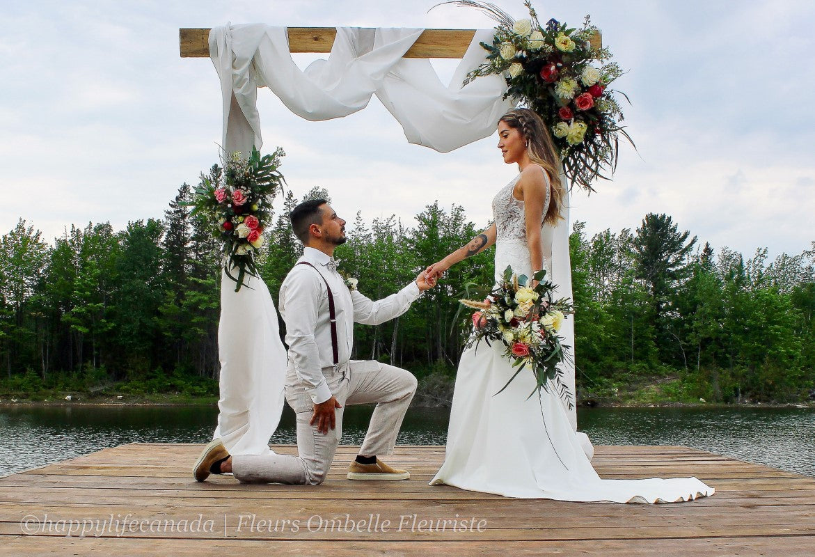 Couple qui se marie sous l'arche de mariage