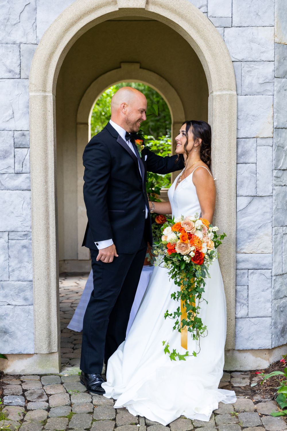 Couple qui se regarde à l'entrée du pavillon pour un mariage chic-classique orange