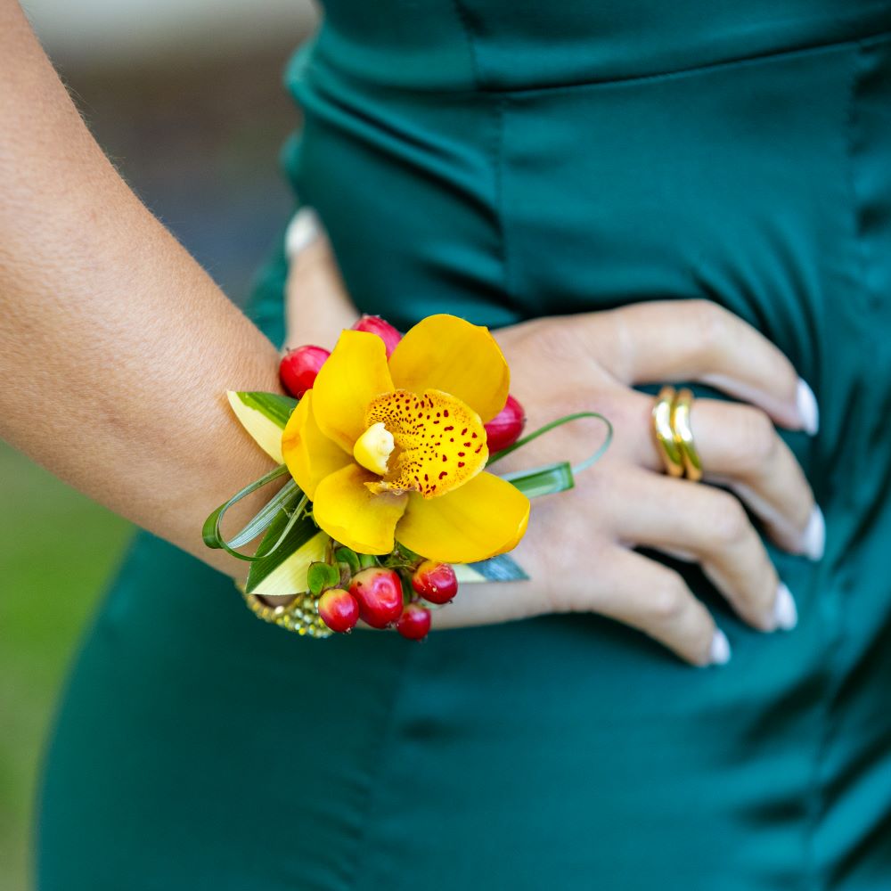 Bracelet fleuri jaune-rouge pour demoiselle dans un mariage exotique