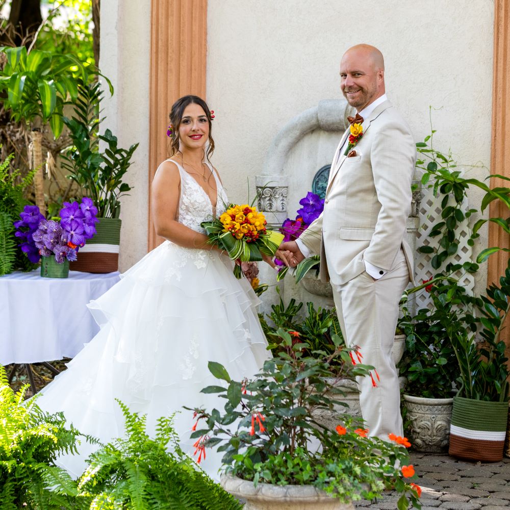 Couple debout pour un mariage exotique jaune-rouge